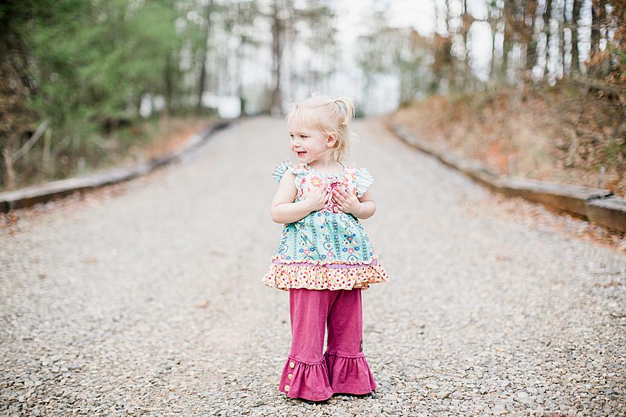 little girl standing on gravel road