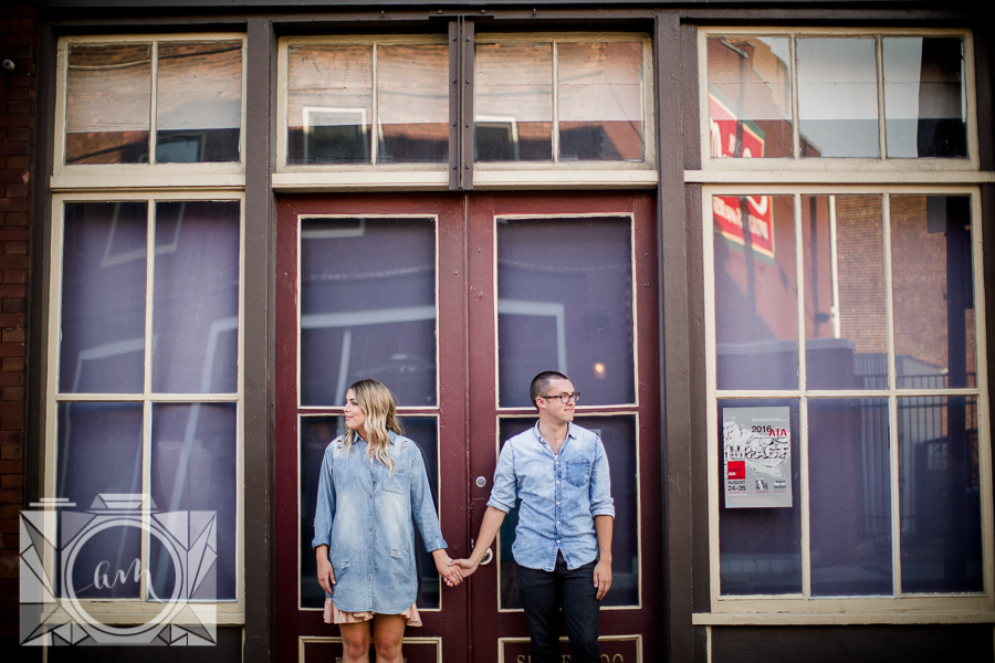 Holding hands in front of doors engagement photo by Knoxville Wedding Photographer, Amanda May Photos.