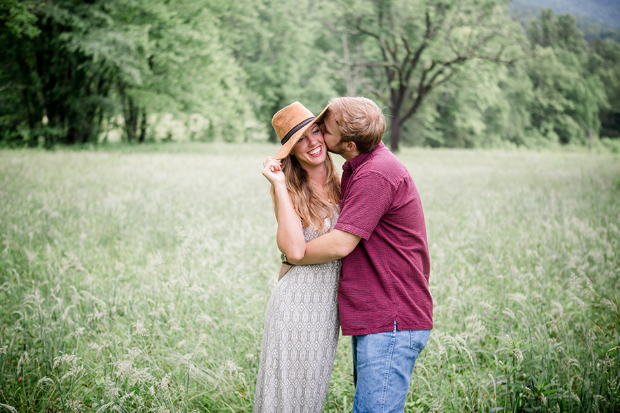 Kissing under her hat engagement photo by Knoxville Wedding Photographer, Amanda May Photos.