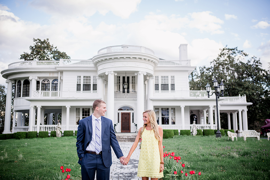 Holding hands in front of mansion engagement photo by Knoxville Wedding Photographer, Amanda May Photos.