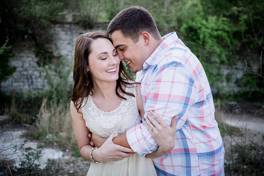 Whispering with his arms engagement photo by Knoxville Wedding Photographer, Amanda May Photos.