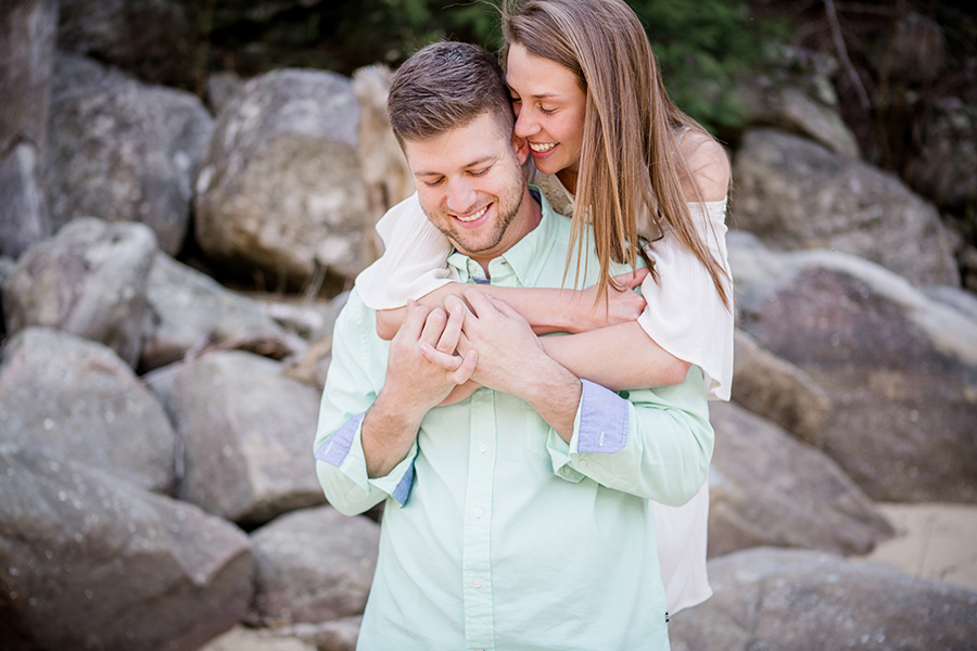 She wraps her arms around his neck engagement photo by Knoxville Wedding Photographer, Amanda May Photos.