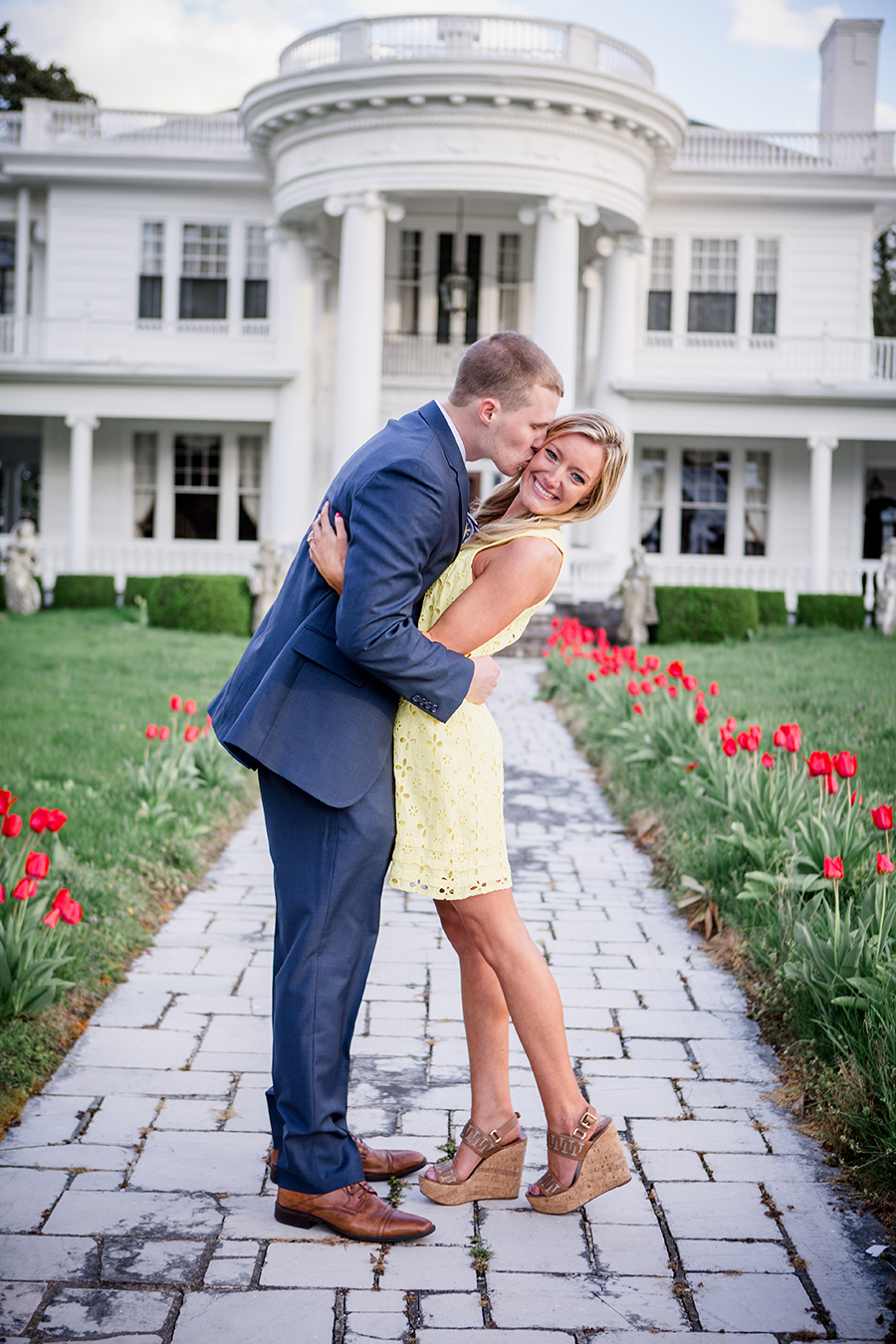 Kisses her cheek in middle of tulips engagement photo by Knoxville Wedding Photographer, Amanda May Photos.