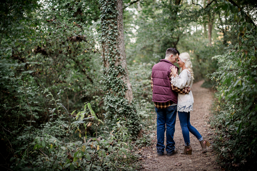 He pulls her in on a trail engagement photo by Knoxville Wedding Photographer, Amanda May Photos.