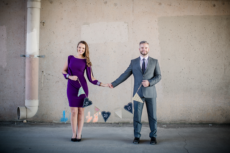 Holding hands and a banner engagement photo by Knoxville Wedding Photographer, Amanda May Photos.