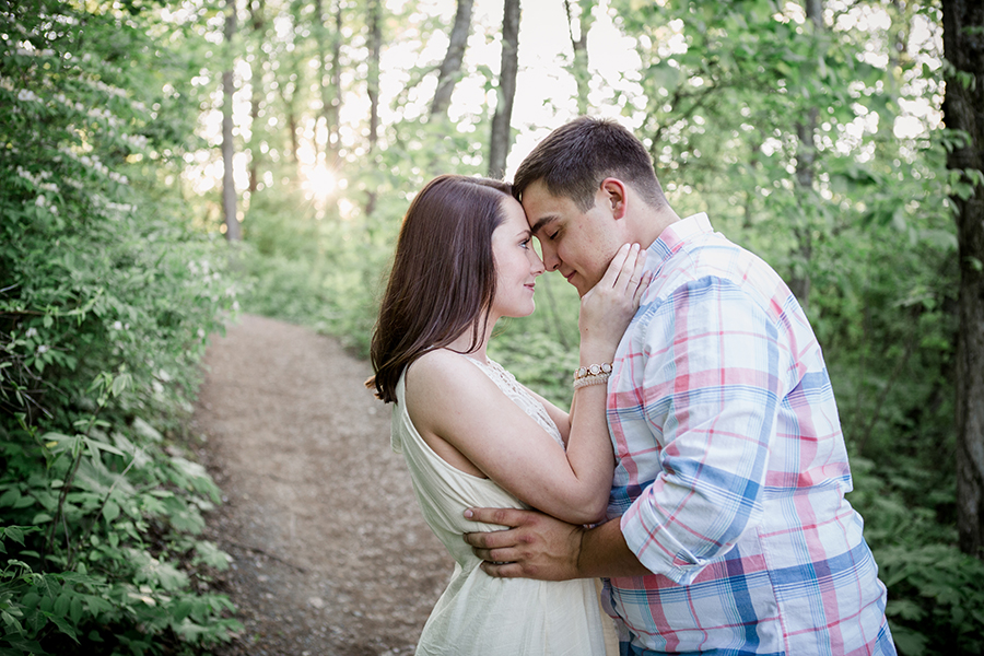 she pulls his cheeks towards her face engagement photo by Knoxville Wedding Photographer, Amanda May Photos.