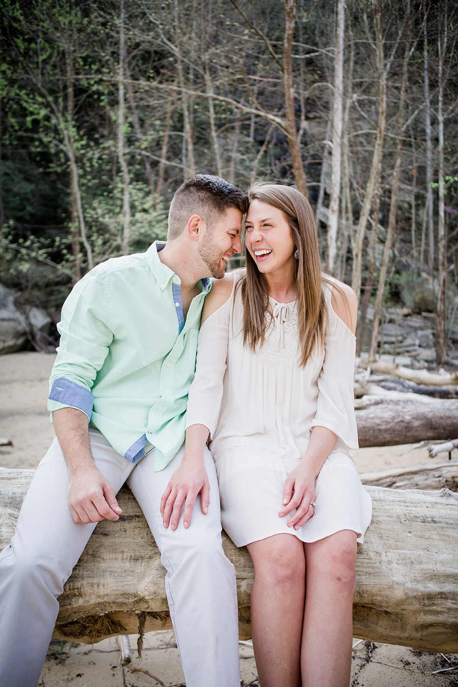 Laughing sitting on a log engagement photo by Knoxville Wedding Photographer, Amanda May Photos.
