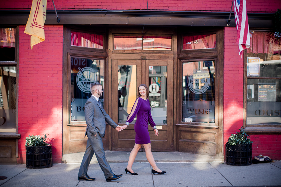 Walking in front of restaurant engagement photo by Knoxville Wedding Photographer, Amanda May Photos.