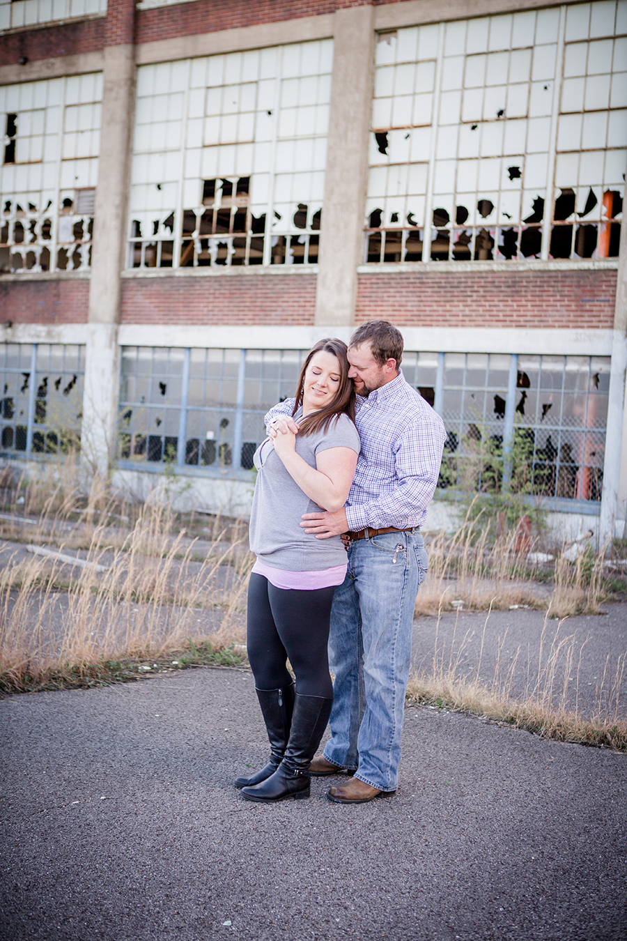 Standing in front of warehouse engagement photo by Knoxville Wedding Photographer, Amanda May Photos.