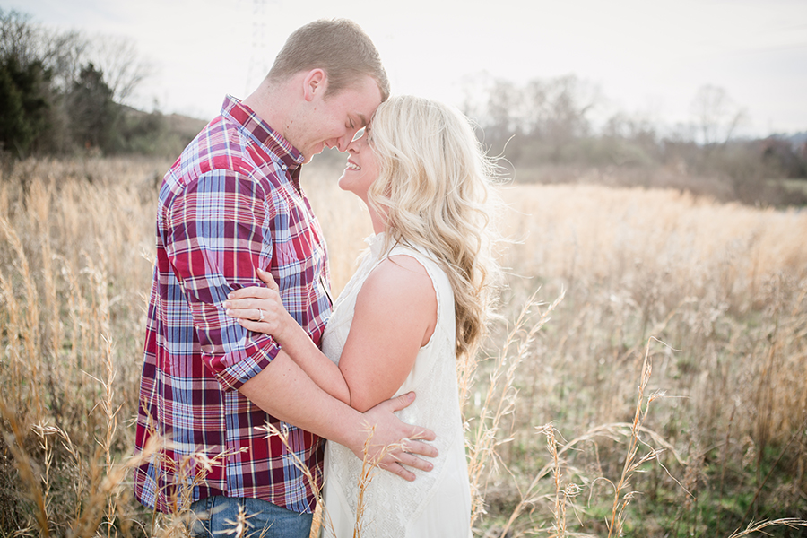 Grassy sunset with foreheads together engagement photo by Knoxville Wedding Photographer, Amanda May Photos.