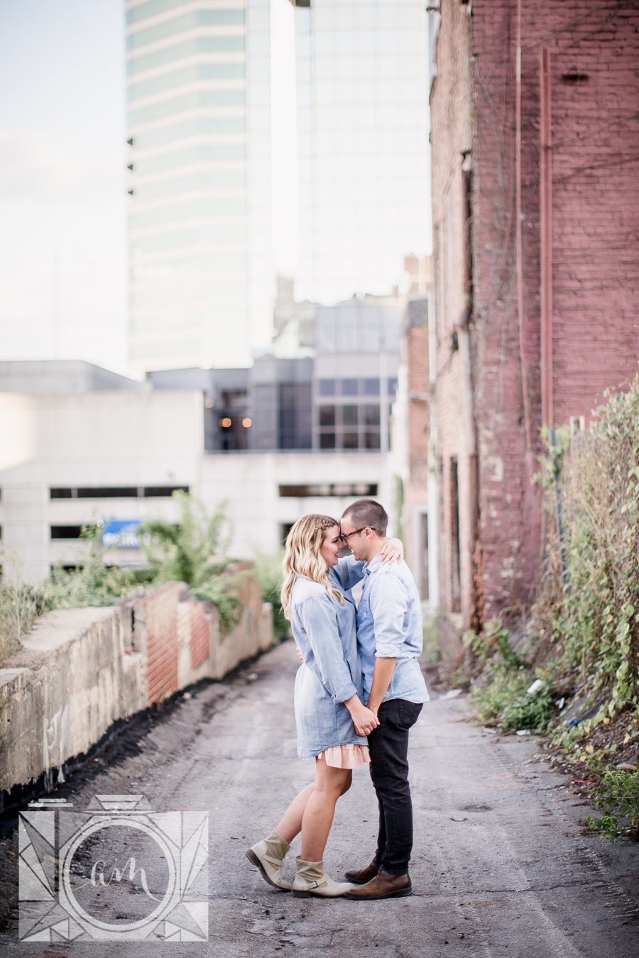 Standing in alley with foreheads together engagement photo by Knoxville Wedding Photographer, Amanda May Photos.