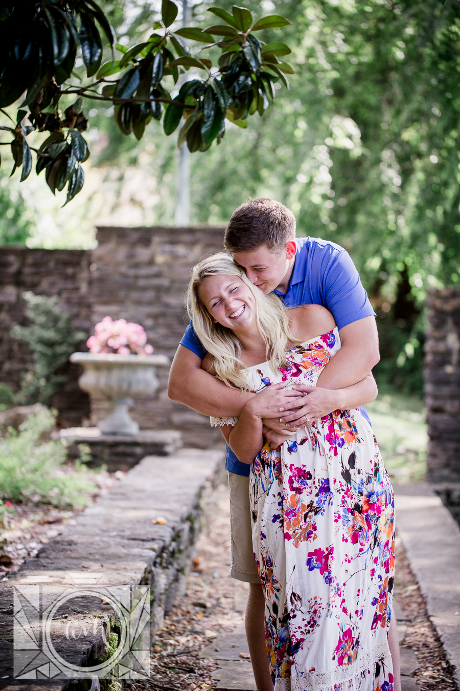 Hugging her from behind leaning engagement photo by Knoxville Wedding Photographer, Amanda May Photos.