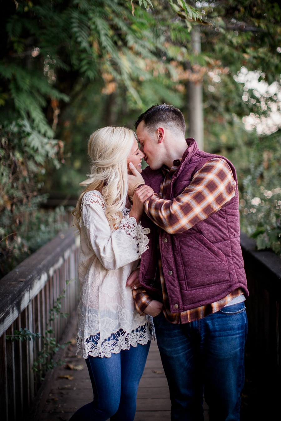 Reaching across kissing her while walking engagement photo by Knoxville Wedding Photographer, Amanda May Photos.
