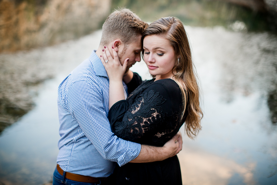 Her hands on his cheeks looking down over her shoulder engagement photo by Knoxville Wedding Photographer, Amanda May Photos.