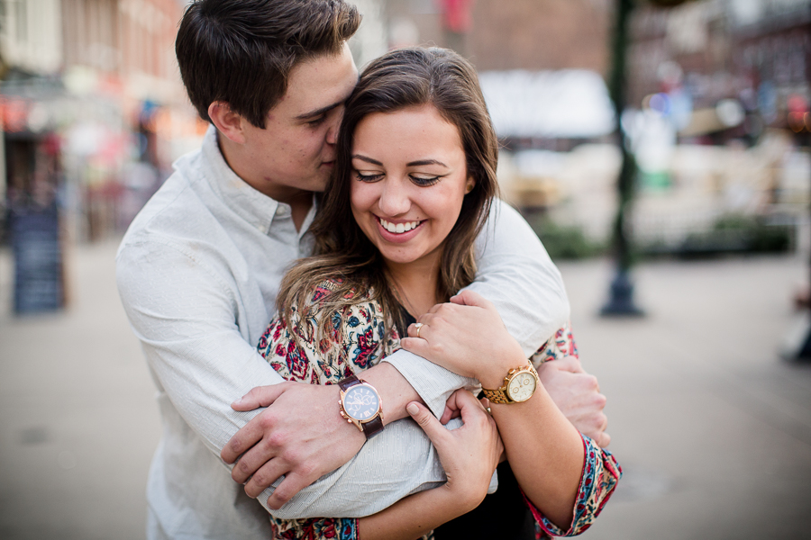 Holding onto the arms around her neck engagement photo by Knoxville Wedding Photographer, Amanda May Photos.