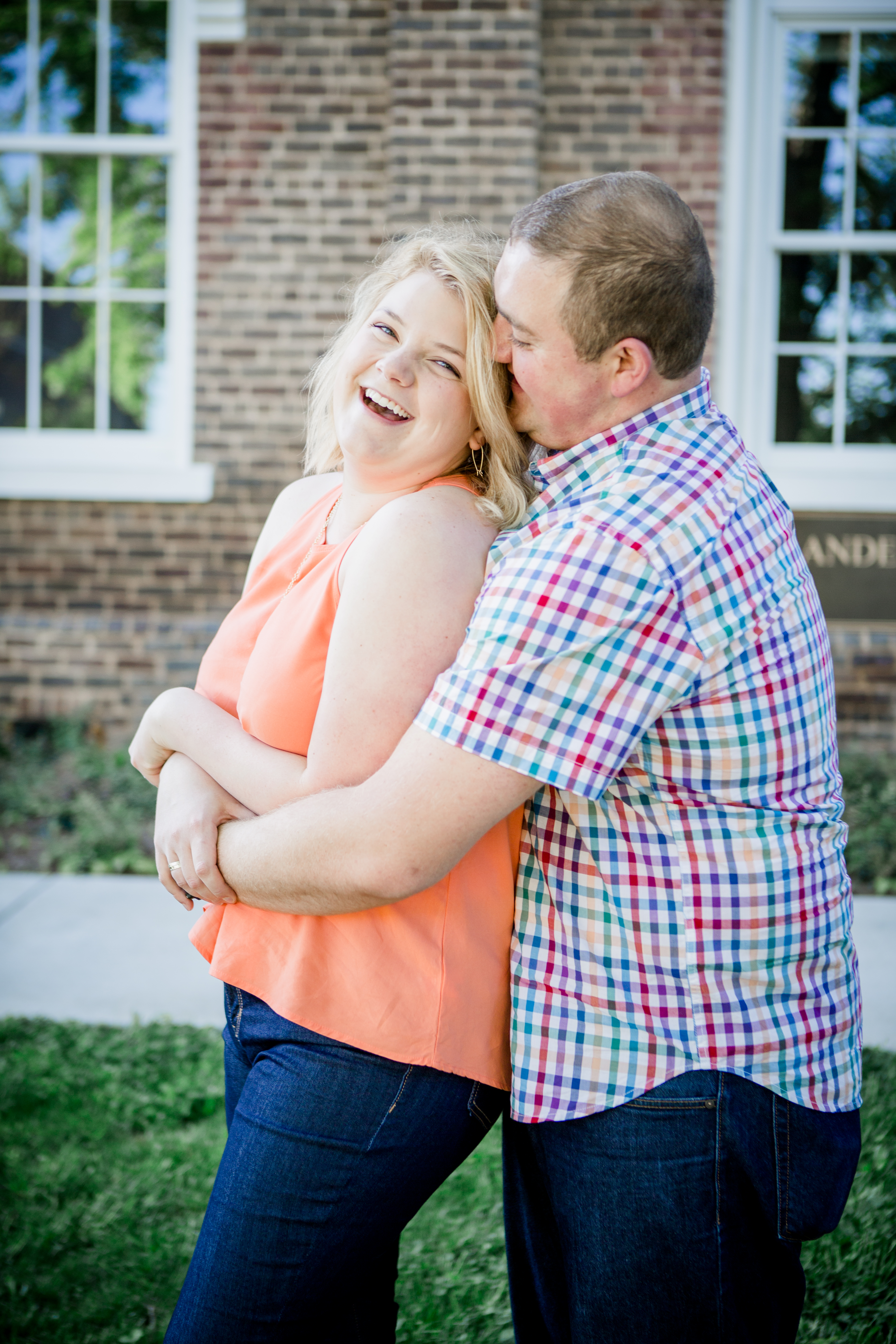 He hugs her from behind and she laughs by Knoxville Wedding Photographer, Amanda May Photos.