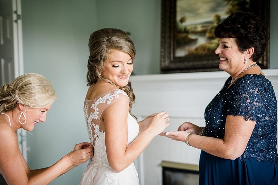 Buttoning the dress at this Castleton Farms Wedding by Knoxville Wedding Photographer, Amanda May Photos.
