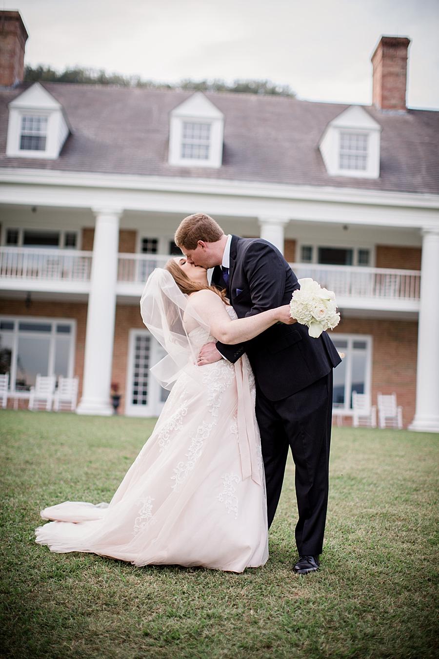 Bride and groom kissing in front of house at this Christopher Place wedding by Knoxville Wedding Photographer, Amanda May Photos