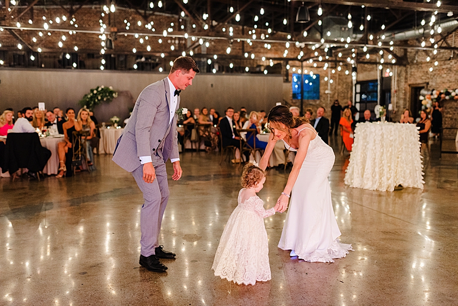 bride and groom dancing with daughter