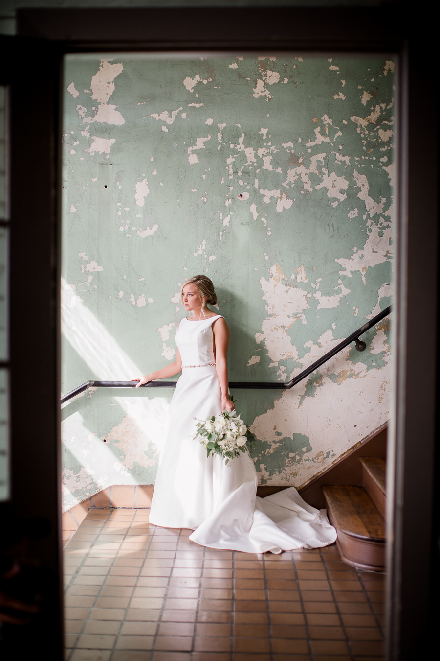 Bride standing in staircase looking out window at this wedding at The Standard by Knoxville Wedding Photographer, Amanda May Photos.
