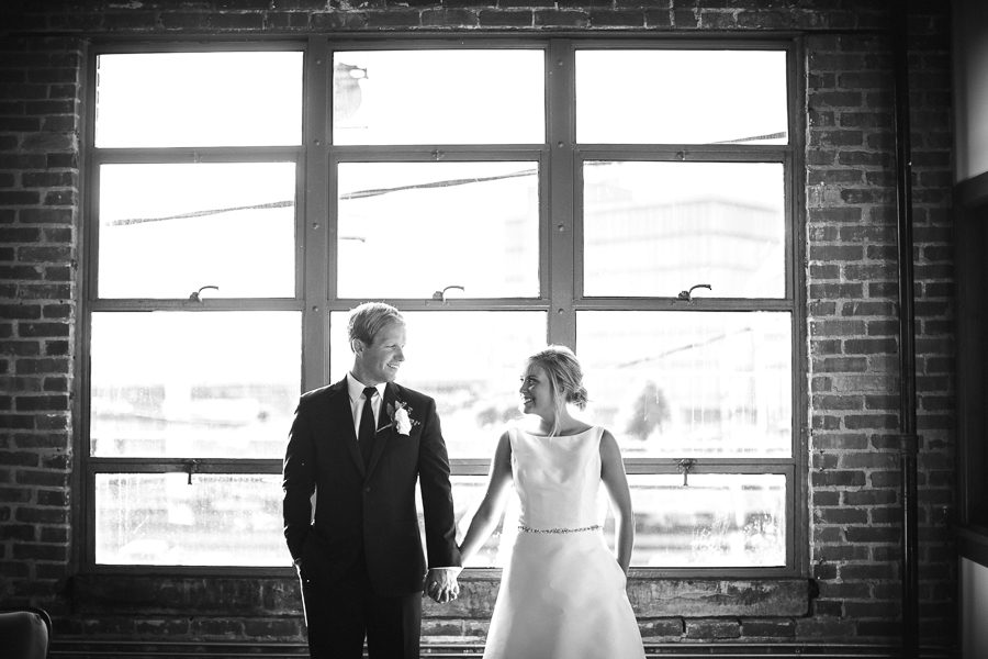 Holding hands in front of window at this wedding at The Standard by Knoxville Wedding Photographer, Amanda May Photos.