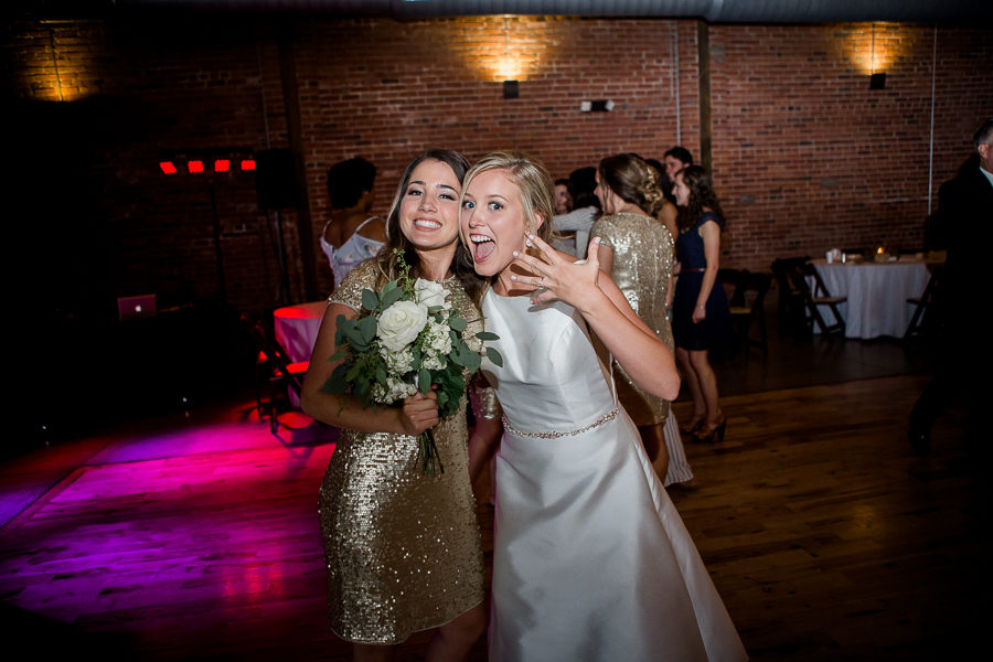Bride with bridesmaid at this wedding at The Standard by Knoxville Wedding Photographer, Amanda May Photos.