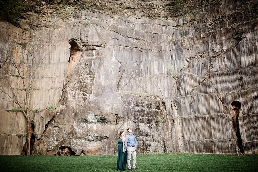 Back to back in front of rock wall at this Knoxville engagement session at The Quarry by Knoxville Wedding Photographer, Amanda May Photos.