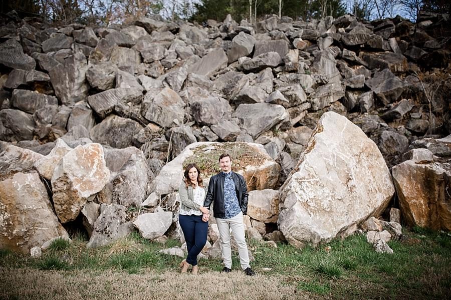 Standing in front of a pile of rocks at this Knoxville engagement session at The Quarry by Knoxville Wedding Photographer, Amanda May Photos.