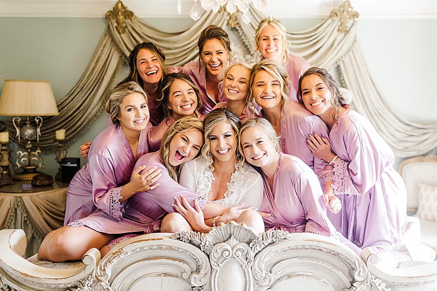 bride and bridesmaids on bed at castleton wedding