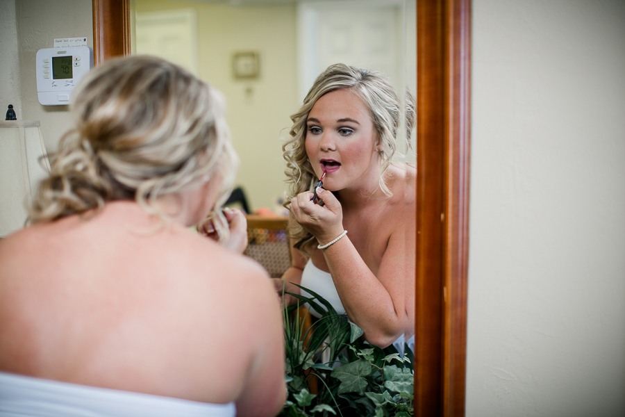 Bride putting on lipstick at this Daytona Beach Wedding by Destination Wedding Photographer, Amanda May Photos.