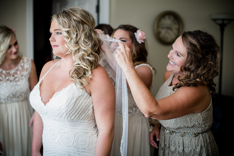 Helping bride get ready at this Daytona Beach Wedding by Destination Wedding Photographer, Amanda May Photos.