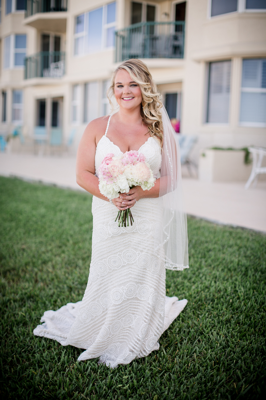 Bride in front of hotel at this Daytona Beach Wedding by Destination Wedding Photographer, Amanda May Photos.