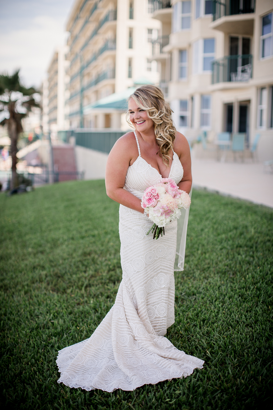 Bride looking over shoulder at beach at this Daytona Beach Wedding by Destination Wedding Photographer, Amanda May Photos.