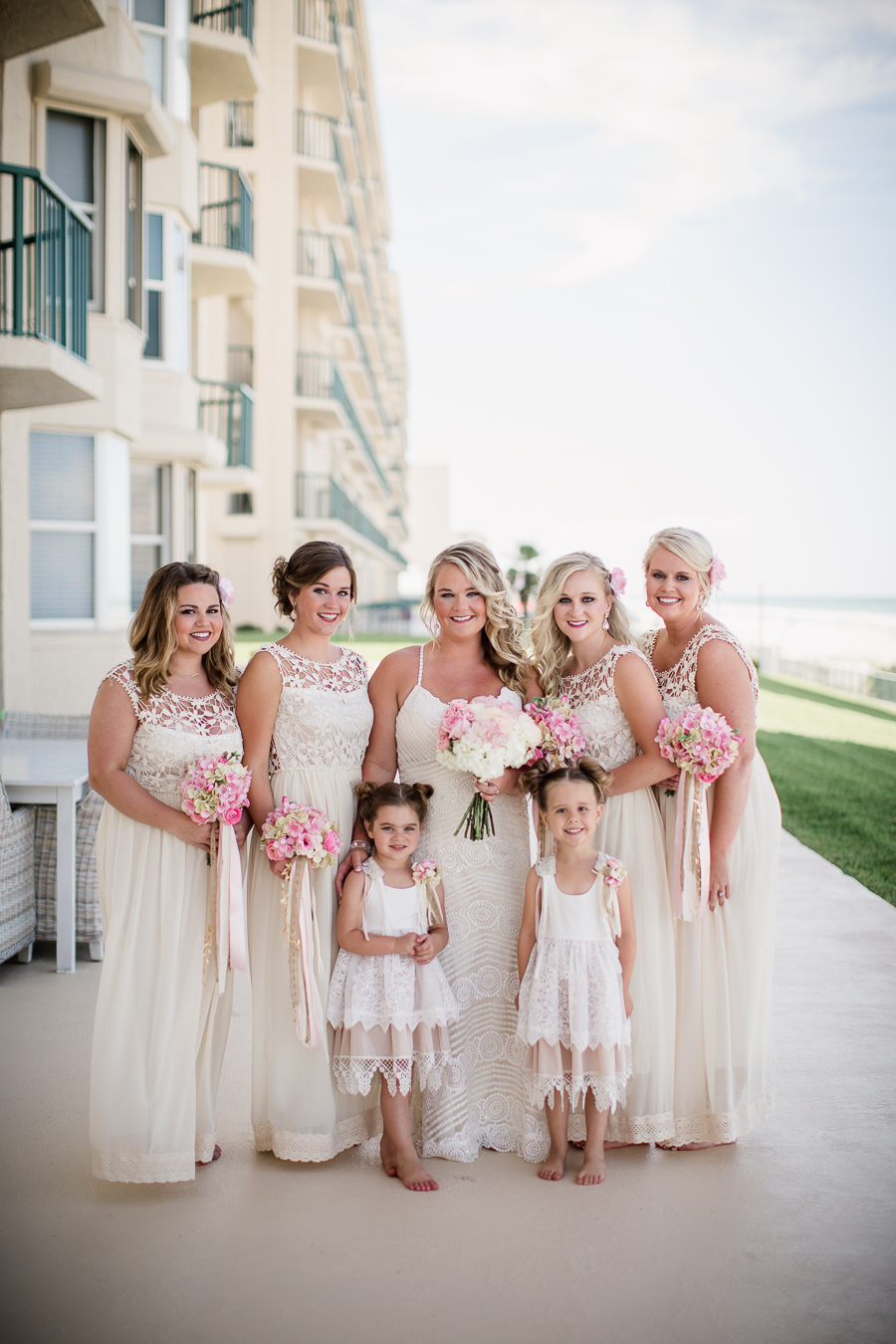 Bride with her bridesmaids and flower girls in front of hotel at this Daytona Beach Wedding by Destination Wedding Photographer, Amanda May Photos.
