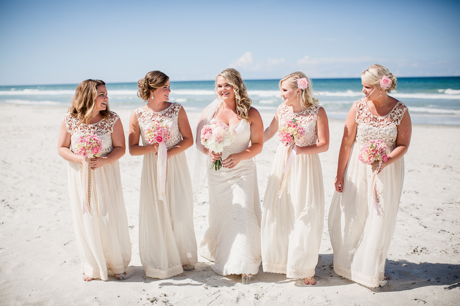 Bride smiling at bridesmaids on the beach at this Daytona Beach Wedding by Destination Wedding Photographer, Amanda May Photos.