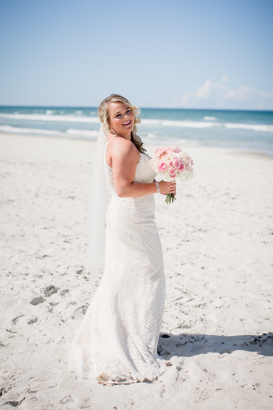 Bride looking over shoulder on beach at this Daytona Beach Wedding by Destination Wedding Photographer, Amanda May Photos.