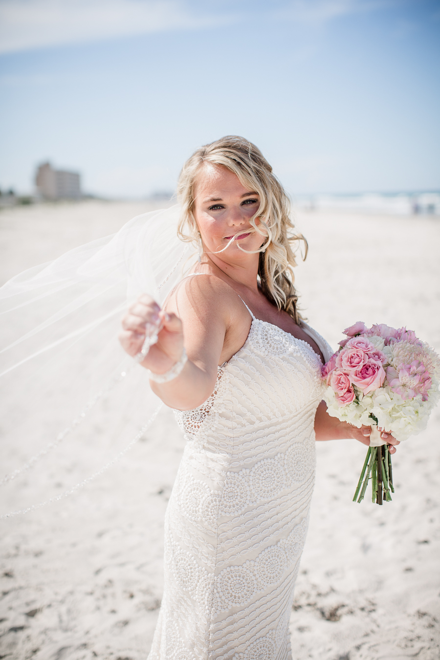 Bride holding out vail on the beach at this Daytona Beach Wedding by Destination Wedding Photographer, Amanda May Photos.