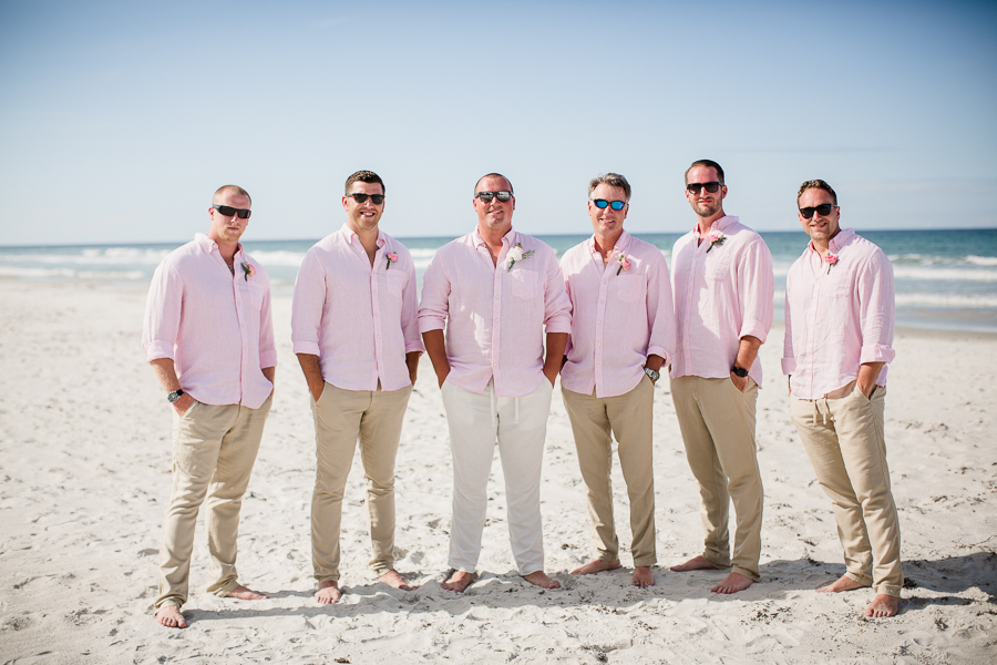 Grooms with groomsmen wearing sunglasses on beach at this Daytona Beach Wedding by Destination Wedding Photographer, Amanda May Photos.
