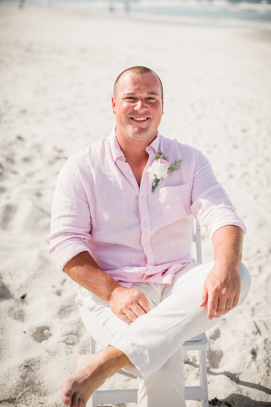 Groom sitting in chair on beach at this Daytona Beach Wedding by Destination Wedding Photographer, Amanda May Photos.