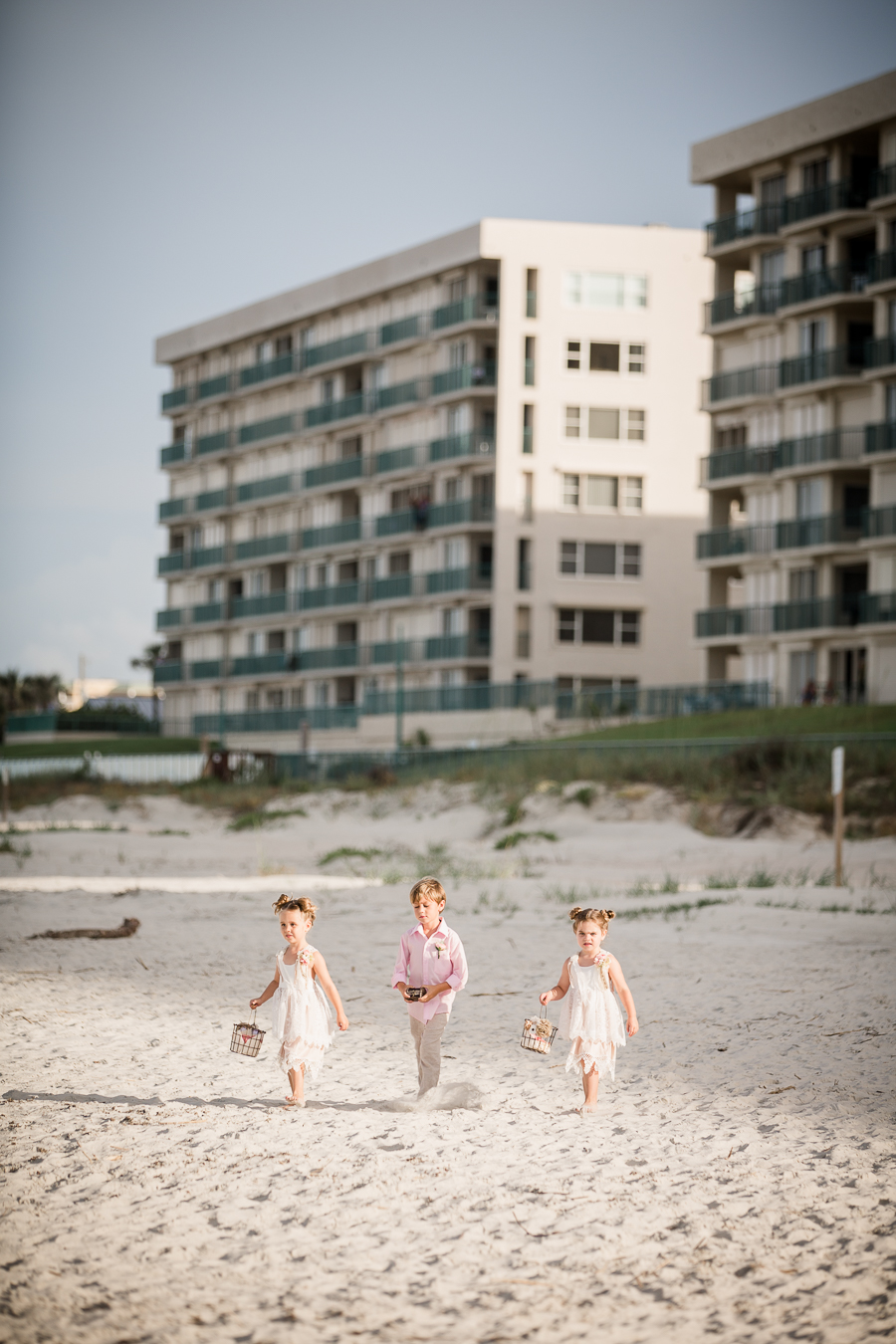 Flower girls and ring bear walking down beach at this Daytona Beach Wedding by Destination Wedding Photographer, Amanda May Photos.