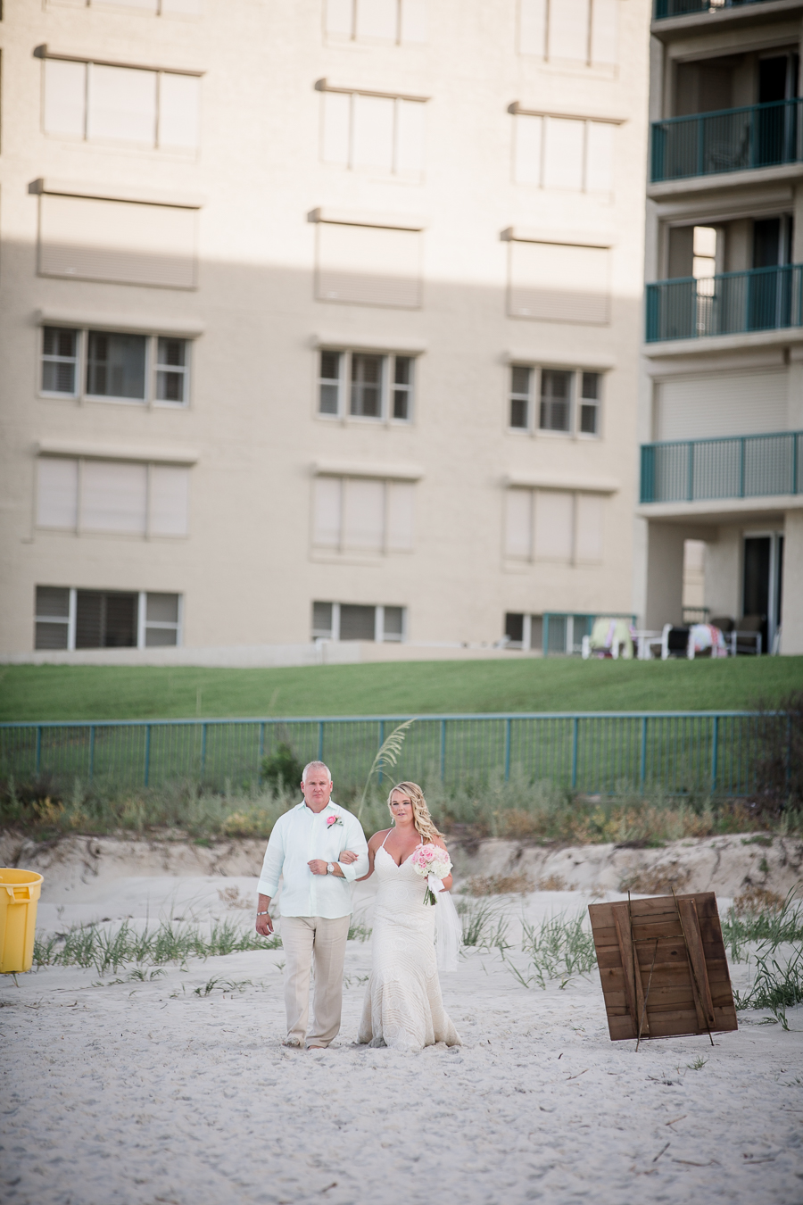 Bride walking down beach with father at this Daytona Beach Wedding by Destination Wedding Photographer, Amanda May Photos.