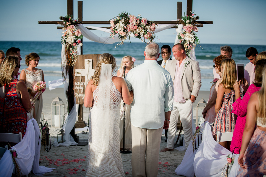 View from behind of father walking bride down the alter at this Daytona Beach Wedding by Destination Wedding Photographer, Amanda May Photos.