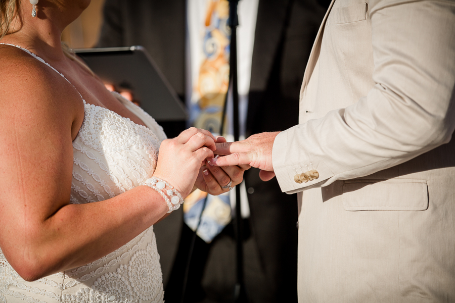 Bride putting ring on groom at this Daytona Beach Wedding by Destination Wedding Photographer, Amanda May Photos.