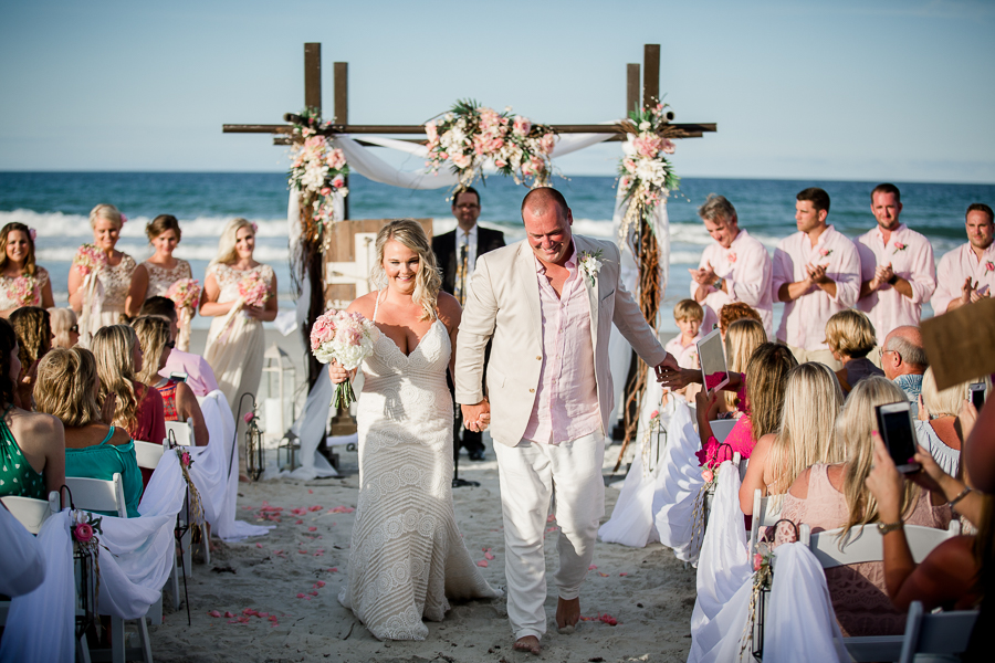 Bride and Groom walking out of ceremony at this Daytona Beach Wedding by Destination Wedding Photographer, Amanda May Photos.