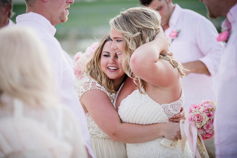 Bridesmaid hugging bride after ceremony at this Daytona Beach Wedding by Destination Wedding Photographer, Amanda May Photos.