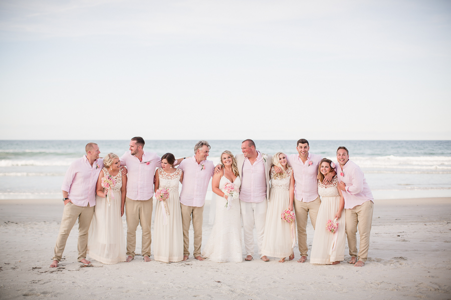 Bridal Party with arms around each other laughing at this Daytona Beach Wedding by Destination Wedding Photographer, Amanda May Photos.