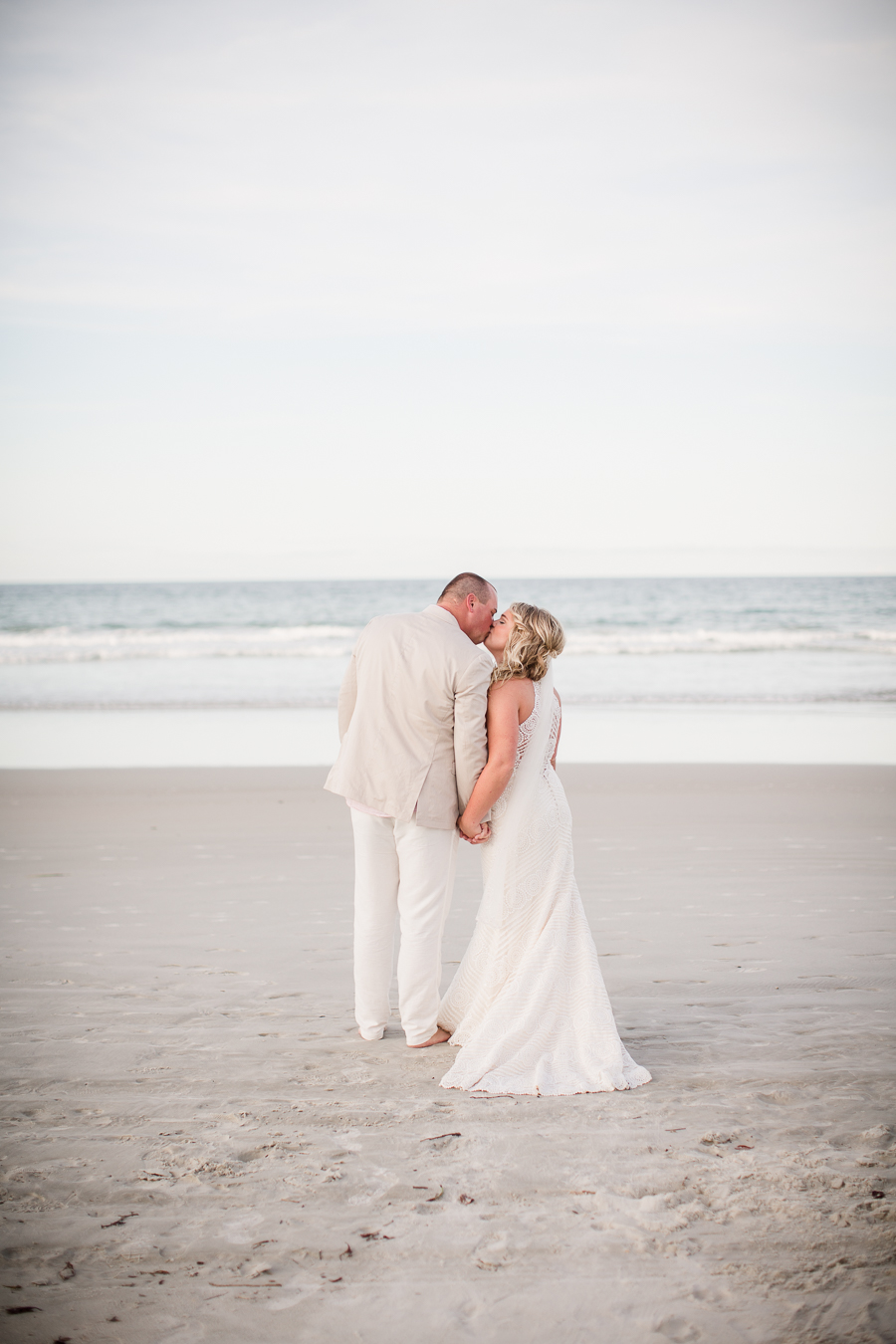 Kissing in front of water at this Daytona Beach Wedding by Destination Wedding Photographer, Amanda May Photos.