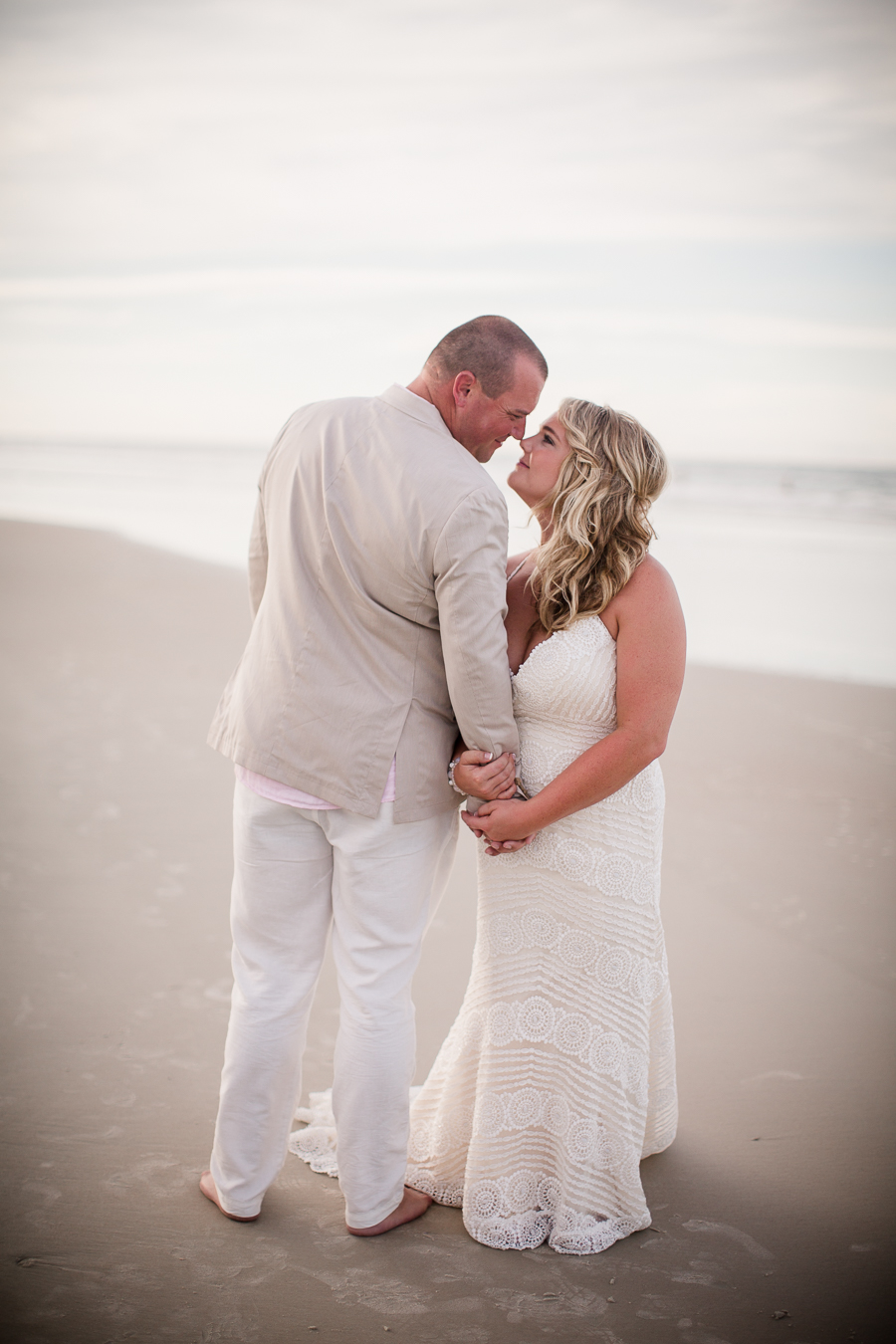Looking at each other in front of water at this Daytona Beach Wedding by Destination Wedding Photographer, Amanda May Photos.