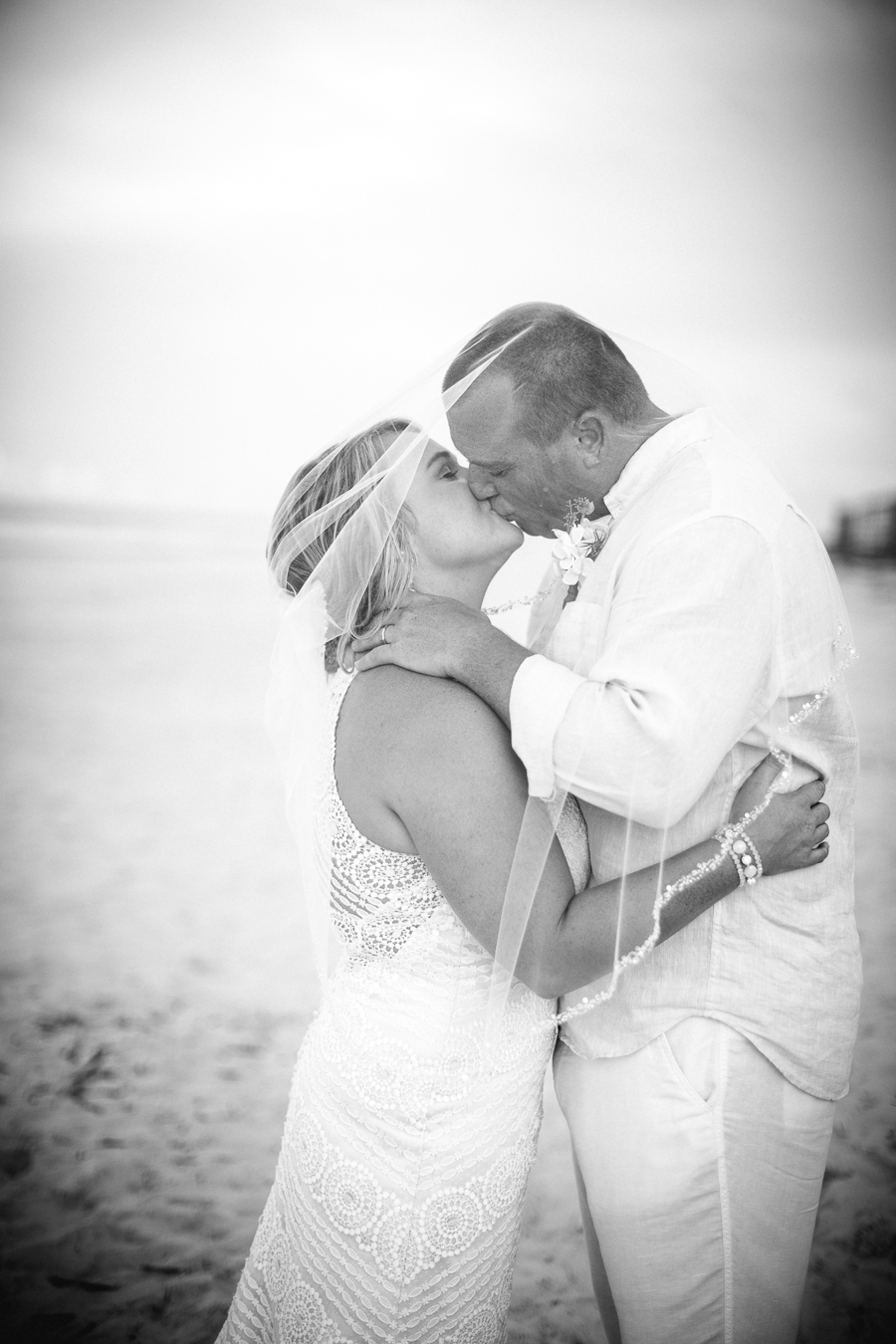 Black and White of kissing under vail at this Daytona Beach Wedding by Destination Wedding Photographer, Amanda May Photos.