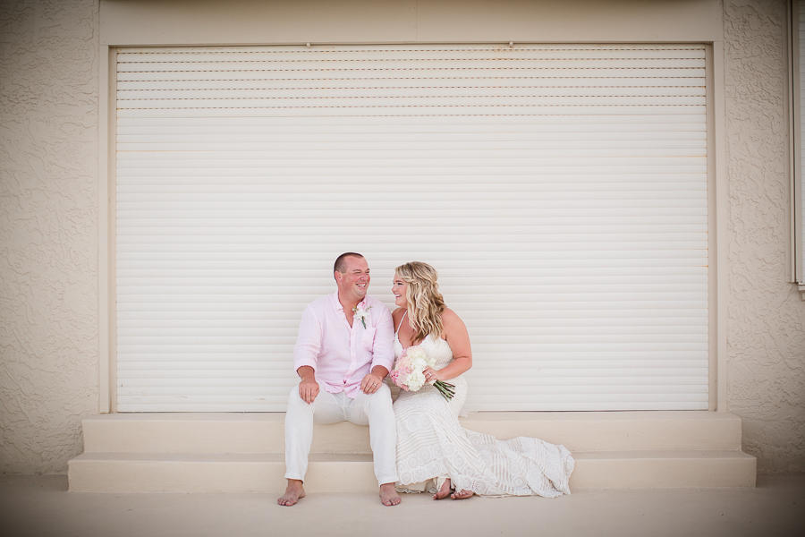 Bride and groom sitting looking at each other at this Daytona Beach Wedding by Destination Wedding Photographer, Amanda May Photos.